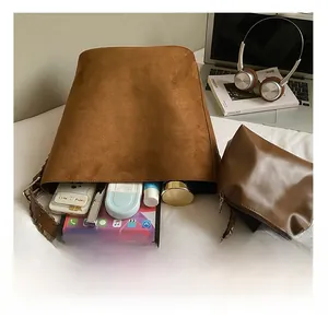 Macro detail of spacious brown suede tote bag interior with matching zipper pouch