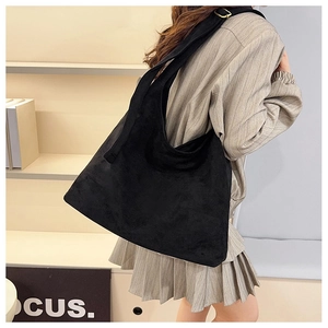 Vue latérale du grand sac cabas en daim noir montrant sa texture mate et souple