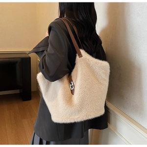 Detail of soft cream plush tote bag with contrasting brown faux leather shoulder strap