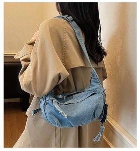 Details der blauen Denim-Hobo-Tasche mit gewaschener Textur und ausgefranstem Design