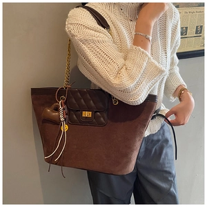 Close-up of vintage dark brown matte tote bag with gold chain strap and quilted pocket