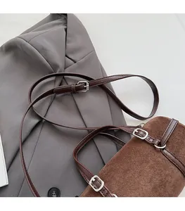 Close-up of brown suede bag showing fine texture and adjustable silver buckle strap