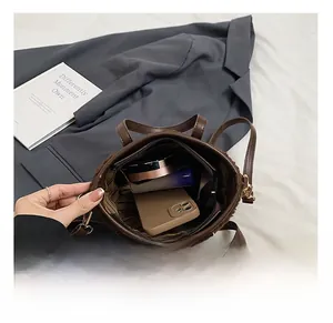 Top view of brown plush bucket bag interior showing phone and cosmetics storage