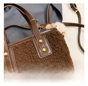 Detailed macro of dark brown faux fur bucket bag with gold rivets and plush charm