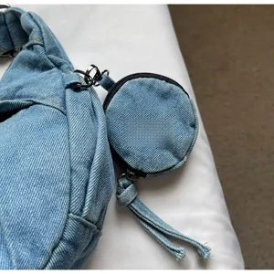Detail der blauen gewaschenen Denim-Umhängetasche mit abnehmbarem runden Münzfach und Zipper