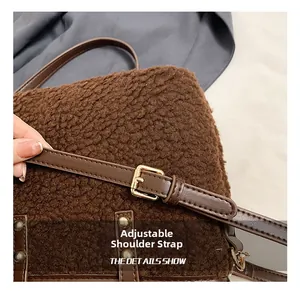 Close-up of adjustable leather shoulder strap with gold buckle on plush brown bucket bag