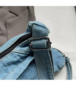 Detailansicht der Denim-Tasche mit schwarzem Reißverschluss und Metallschnalle am Tragegurt