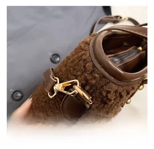 Detail view of premium golden metal hooks and plush brown fabric texture on bucket bag