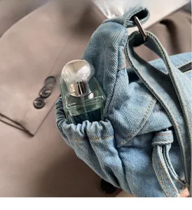 Detail der blauen Denim-Umhängetasche mit elastischer Seitentasche und hohem Fassungsvermögen