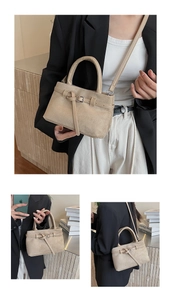 Detailaufnahme der Wildleder-Beuteltasche mit eleganter Schnalle und runden Tragegriffen