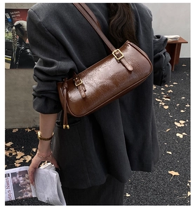 Gros plan sur le sac baguette vintage en cuir plissé marron avec détails dorés