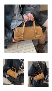 Detail view of brown matte bowling bag with leather handles and metallic hardware accents