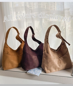 Trois sacs hobo en daim de différentes couleurs exposés à la lumière naturelle du jour