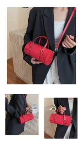 Detail of red suede boston bag featuring silver hardware and adjustable leather strap