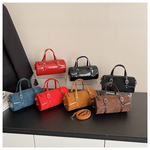 Selection of cylinder Boston bags in diverse colors and finishes on tiered display