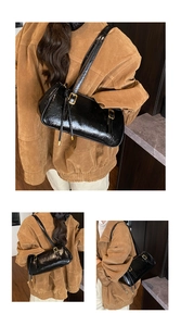 Détail du sac sous le bras noir brillant vintage en cuir froissé et boucle dorée élégante
