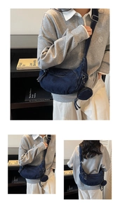 Detailansicht der dunkelblauen Denim-Halbmondtasche mit Gurt und kleiner runder Tasche