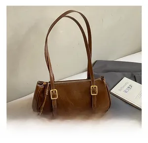 Détails d'un sac sous les bras marron brillant avec texture plissée et boucles dorées