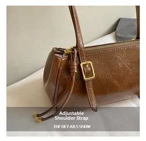 Détail de la bandoulière réglable du sac rétro marron avec une boucle en métal doré