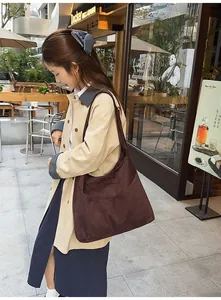 Détail d'un grand sac cabas en daim marron foncé idéal pour les déplacements quotidiens