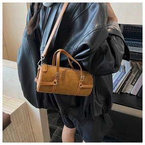 Detailed view of a brown frosted cylinder crossbody bag with silver hardware and strap