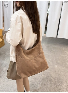 Gros plan sur un grand sac hobo en daim marron avec une poche latérale extérieure pratique