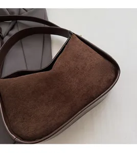 Close-up of the dark brown suede and smooth leather stitching on the shoulder bag