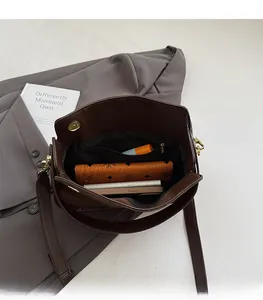 Interior view of brown suede shoulder bag showing spacious main compartment and zipper pocket
