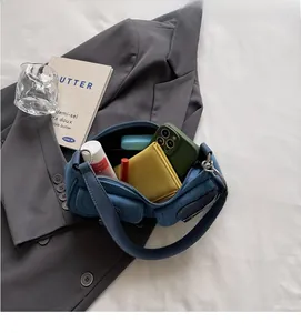 Top view of spacious denim shoulder bag showing interior space for wallet and phone
