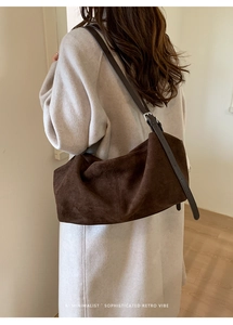 Close-up of a large brown suede tote bag featuring a minimalist sophisticated retro vibe