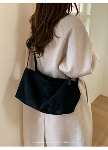 Rear view of model wearing a large black matte leather tote bag for daily commute