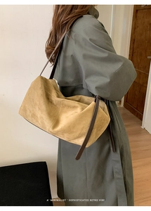 Close-up of a large khaki suede tote bag with brown leather straps for daily commute