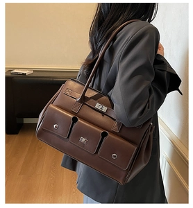 Detail of vintage brown leather underarm bag with triple pockets and silver twist locks
