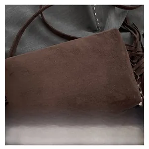 Close-up of deep brown suede texture and delicate fringe details on a commuter tote bag