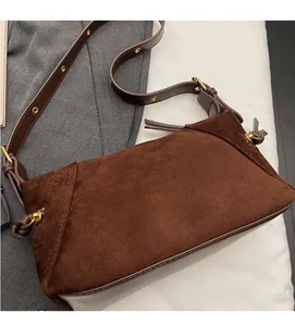 Detailed macro view of retro brown frosted leather texture and gold hardware on bag