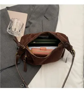 Spacious interior of brown suede hobo bag showing large storage for phone and wallet