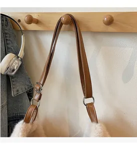 Détail de la bandoulière réglable en cuir et boucles argentées sur le sac en peluche