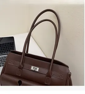 Close-up of chocolate brown tote bag with silver twist lock and reinforced stitching
