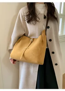 Détail d'un sac à bandoulière jaune vintage avec texture mate et boucle décorative