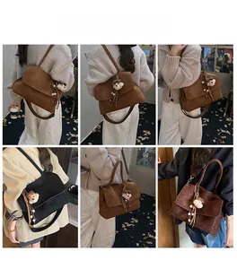 Detail view of large canvas shoulder bag with plush bear charm in multiple colors