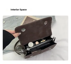 Detail of crossbody bag interior compartments with central zipper pocket and contrast stitching