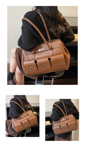 Detail of brown leather shoulder bag featuring front pockets and silver twist lock