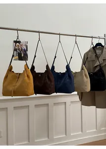 Présentation de cinq grands sacs cabas vintage colorés sur un support métallique