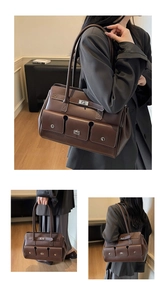 Detail of vintage brown tote bag featuring multiple pockets and silver metal turn locks