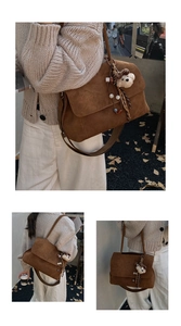 Dettaglio della borsa tote in pelle scamosciata marrone con ciondolo a forma di orso