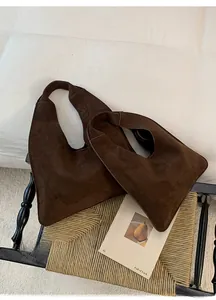 Macro shot of large and small brown suede Hobo bags on a stylish chair background