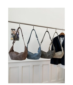 Detailed lineup of four large crescent shoulder bags in neutral earthy color tones