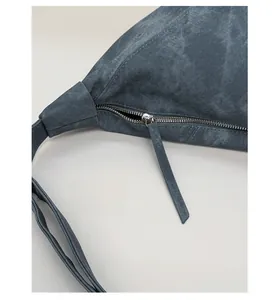 Detailed macro view of the smooth metal zipper closure on this dark gray suede tote bag