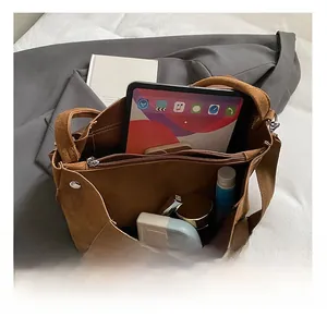 Vista dettagliata dell'ampio interno e dello scomparto con zip della borsa marrone