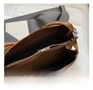Dettaglio borsa tote in pelle scamosciata marrone con zip in metallo e scomparto interno